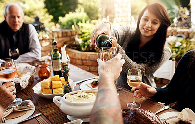 Buy stock photo Food, pouring wine and people eating together at table to celebrate holiday, Christmas or thanksgiving. Family or friends group outdoor for lunch or dinner with alcohol, glass and bottle in summer