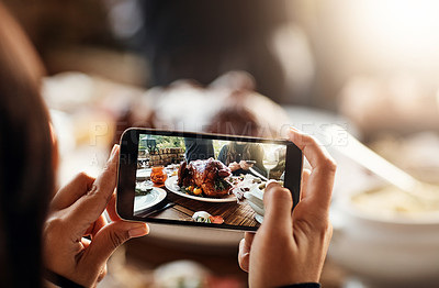 Buy stock photo Cropped shot of an unrecognizable woman taking a picture of a turkey on a dining table on Thanksgiving
