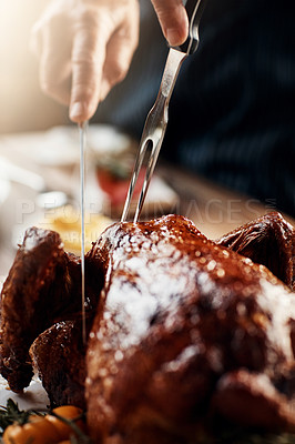 Buy stock photo Closeup shot of an unrecognizable man cutting into a roasted turkey on Thanksgiving