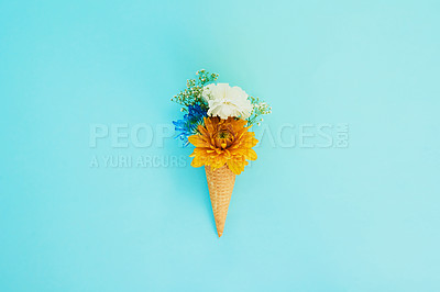 Buy stock photo Floral, ice cream and cone in studio for creativity, art or decoration with fresh and colorful bouquet. Creative, still life and flower plants in dessert isolated by blue background with mockup space