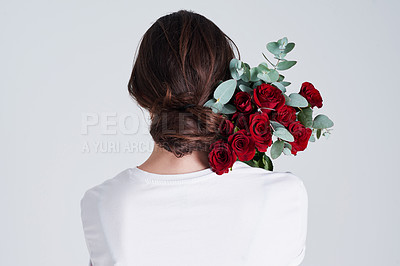 Buy stock photo Studio shot of an unrecognizable woman holding flowers against a grey background