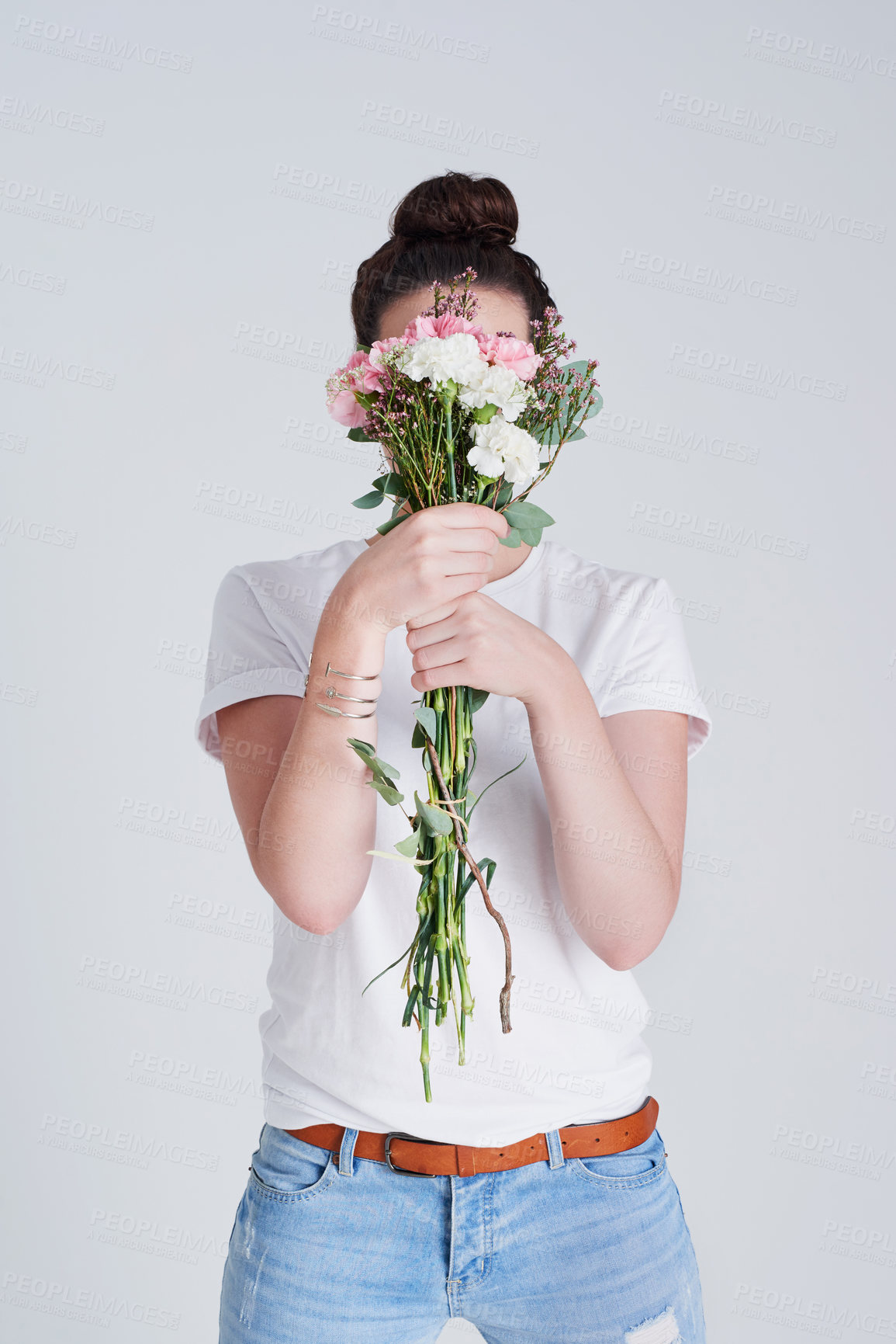 Buy stock photo Gift, girl and flowers in studio for celebration with nature aesthetic and eco friendly arrangement on gray background. Person, bouquet and hide face with present and organic with sustainability