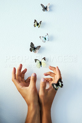 Buy stock photo Studio shot of an unrecognizable person releasing butterflies into the air against a grey background