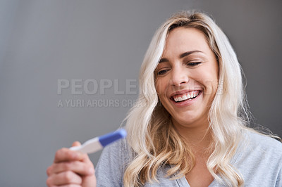 Buy stock photo Shot of a young woman looking at the results of her home pregnancy test