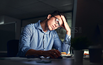 Buy stock photo Tired, stressed businessman suffering from headache, working late night in the office. Serious, frustrated and overworked corporate male with headache staring at his screen in the dark.  