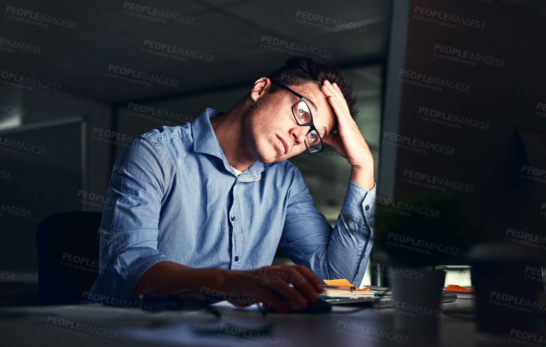Buy stock photo Tired, stressed businessman suffering from headache, working late night in the office. Serious, frustrated and overworked corporate male with headache staring at his screen in the dark.  