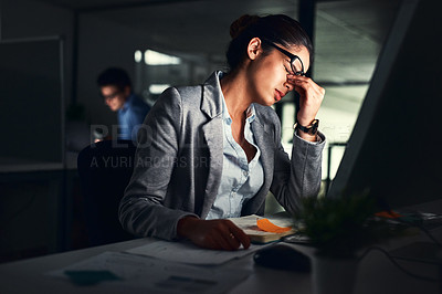 Buy stock photo Stressed business woman working late on a computer in an office at night. Young worried entrepreneur feeling tired while struggling with burnout, eye strain and a headache from deadlines and pressure