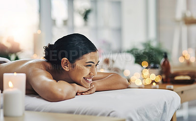 Buy stock photo Shot of a relaxed an cheerful young woman getting a massage indoors at a spa