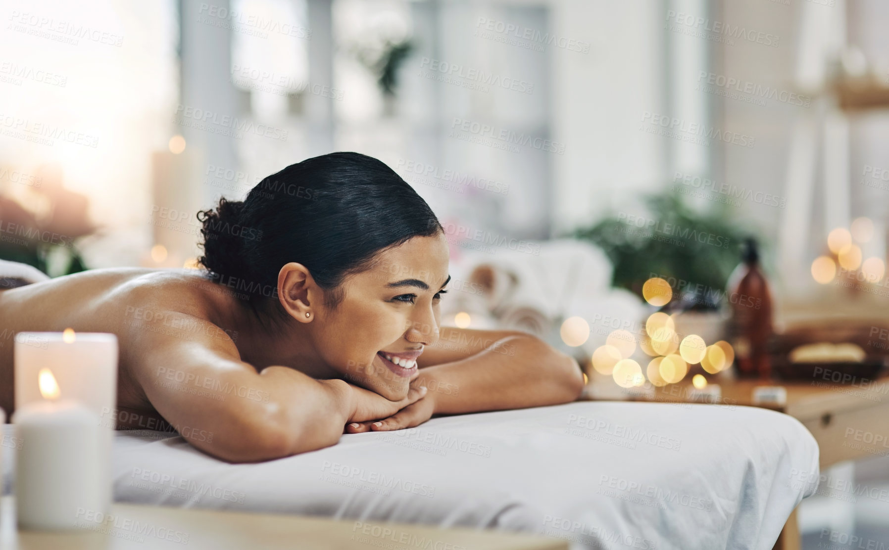 Buy stock photo Shot of a relaxed an cheerful young woman getting a massage indoors at a spa