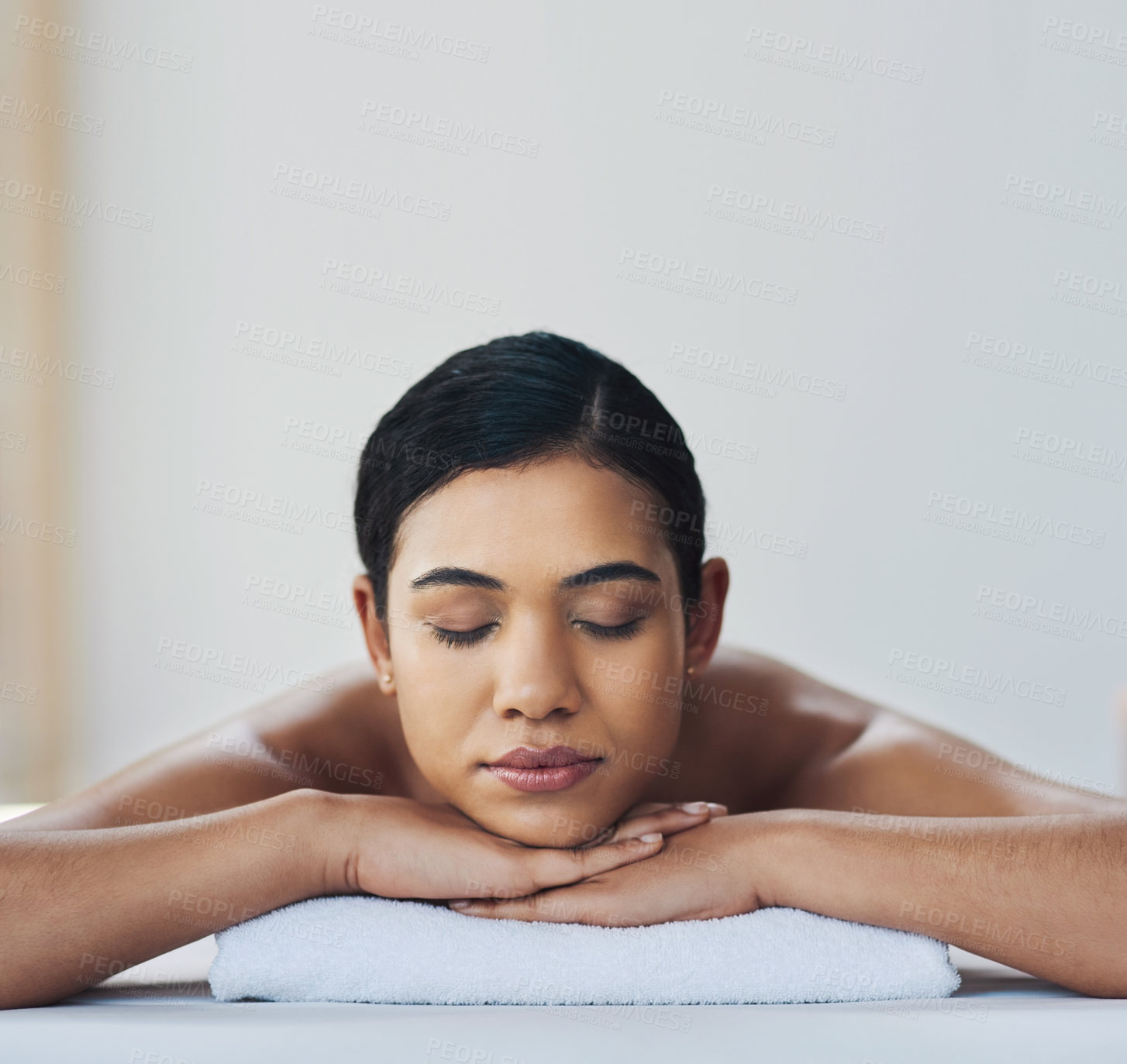 Buy stock photo Shot of a relaxed an cheerful young woman getting a massage indoors at a spa