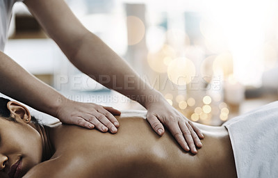 Buy stock photo Shot of a relaxed an cheerful young woman getting a massage indoors at a spa