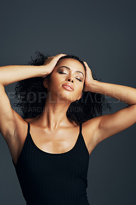 Buy stock photo Studio shot of a beautiful young woman posing against a dark background