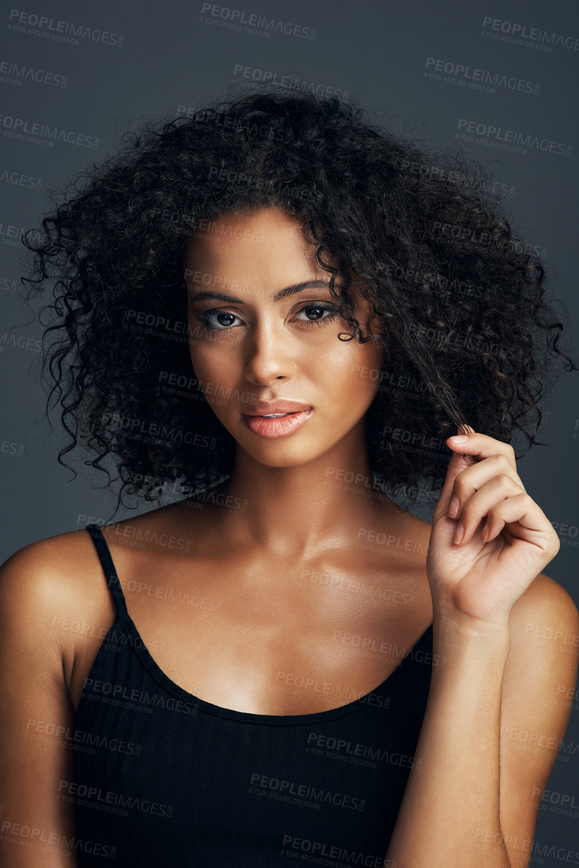 Buy stock photo Studio shot of a beautiful young woman posing against a dark background