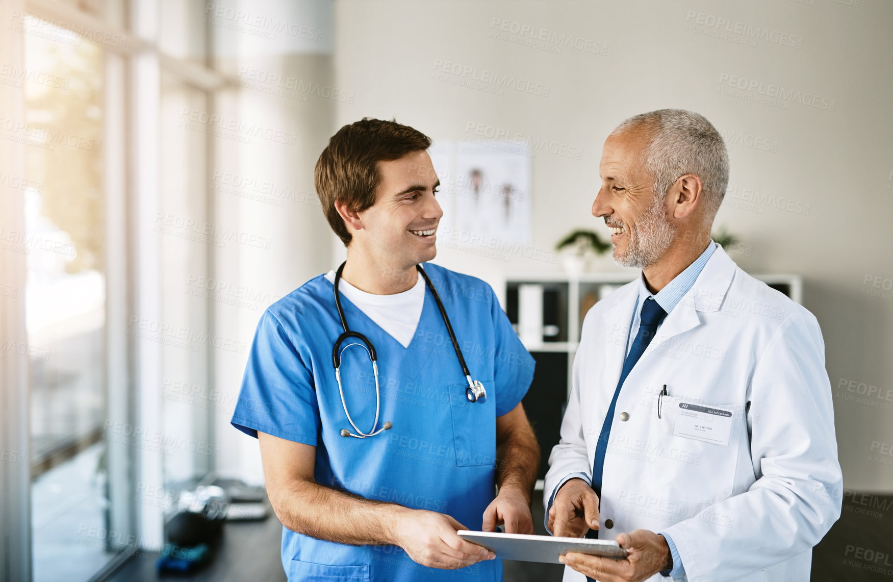 Buy stock photo Doctor, tablet and talking with male nurse in clinic, medical collaboration and together on telehealth or healthcare. Teamwork, speaking and professional research online, hospital update and results