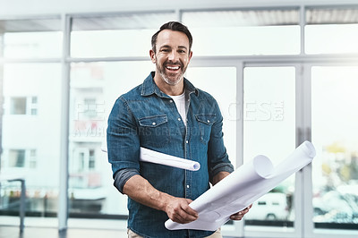 Buy stock photo Portrait of an architect holding blueprints in an office