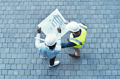 Buy stock photo High angle shot of two engineers looking at a blueprint