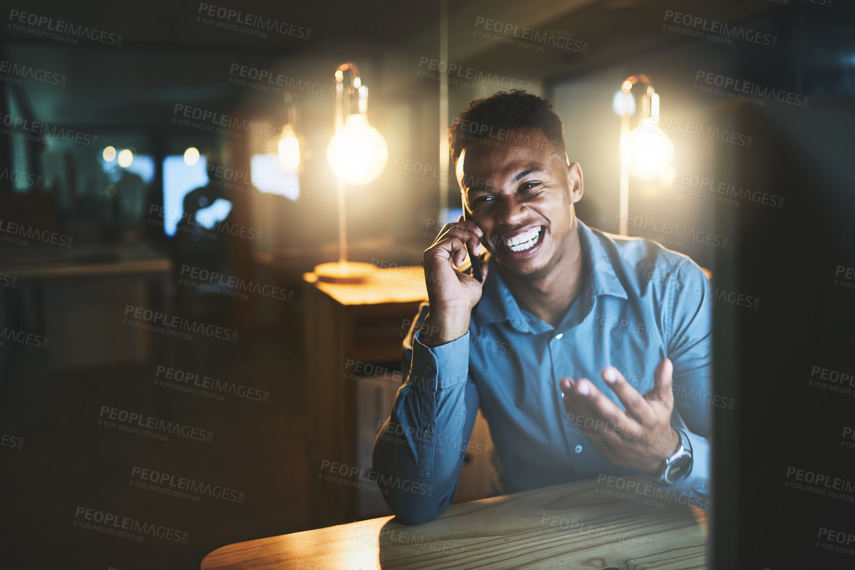 Buy stock photo Cropped shot of a handsome young businessman making a phonecall while working late at night in a modern office