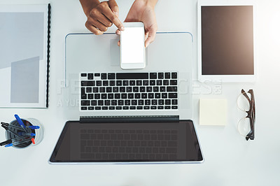 Buy stock photo High angle shot of an unrecognizable woman sitting at her office desk scrolling through her smartphone