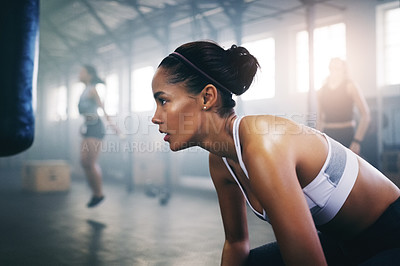 Buy stock photo Cropped shot of a focused young sportswoman in the gym sitting down and taking a break