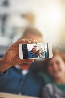 Buy stock photo Closeup of a cheerful little boy and his father taking a self portrait together while being seated on the sofa together
