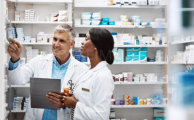 Buy stock photo Shot of two pharmacists working together in a drugstore