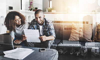 Buy stock photo Shot of a young couple going through their paperwork together at home