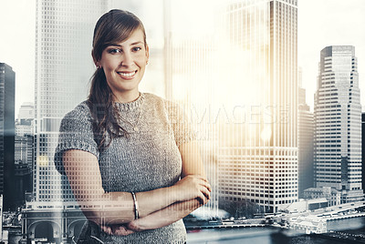 Buy stock photo Portrait of a confident young businesswoman standing with her arms folded inside the office at work