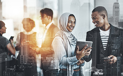 Buy stock photo Shot of a group of young cheerful businesspeople browsing on digital devices while working together in the office at work