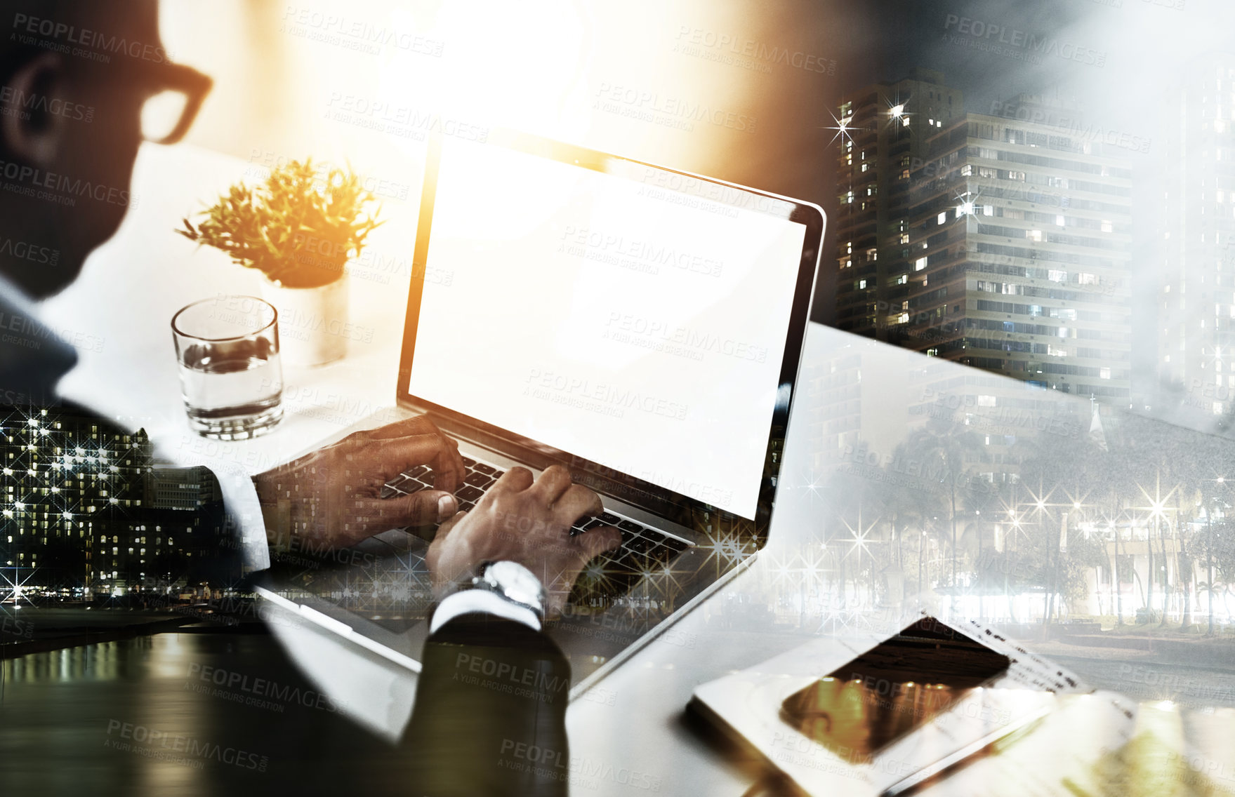 Buy stock photo High angle shot of an unrecognizable young businessman working on his laptop in a modern office