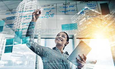 Buy stock photo Shot of a young businesswoman using a digital tablet while writing notes on a glass wall in an office