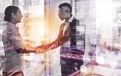 Buy stock photo Shot of two businesspeople shaking hands in an office