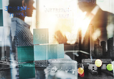 Buy stock photo Shot of notes on a glass wall in an office with two businesspeople having a discussion in the background