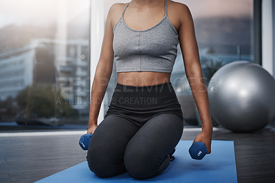 Buy stock photo Cropped shot of an unrecognizable young woman on her knees holding dumbbells while exercising on her gym mat at home