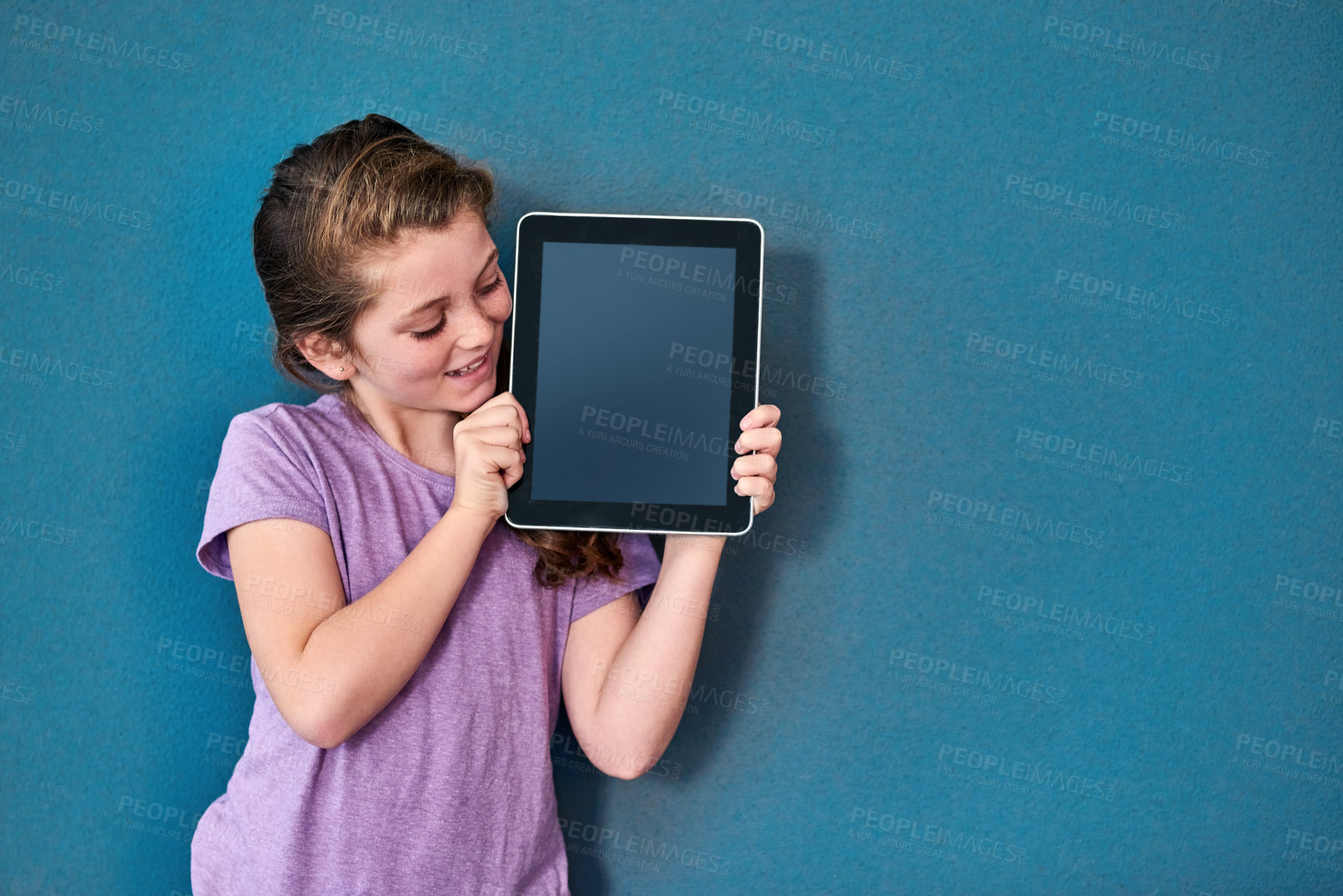 Buy stock photo Girl, child and tablet screen in studio with mockup space for application, ui or elearning by blue background. Kid, digital touchscreen and blank display for user experience, education or scholarship