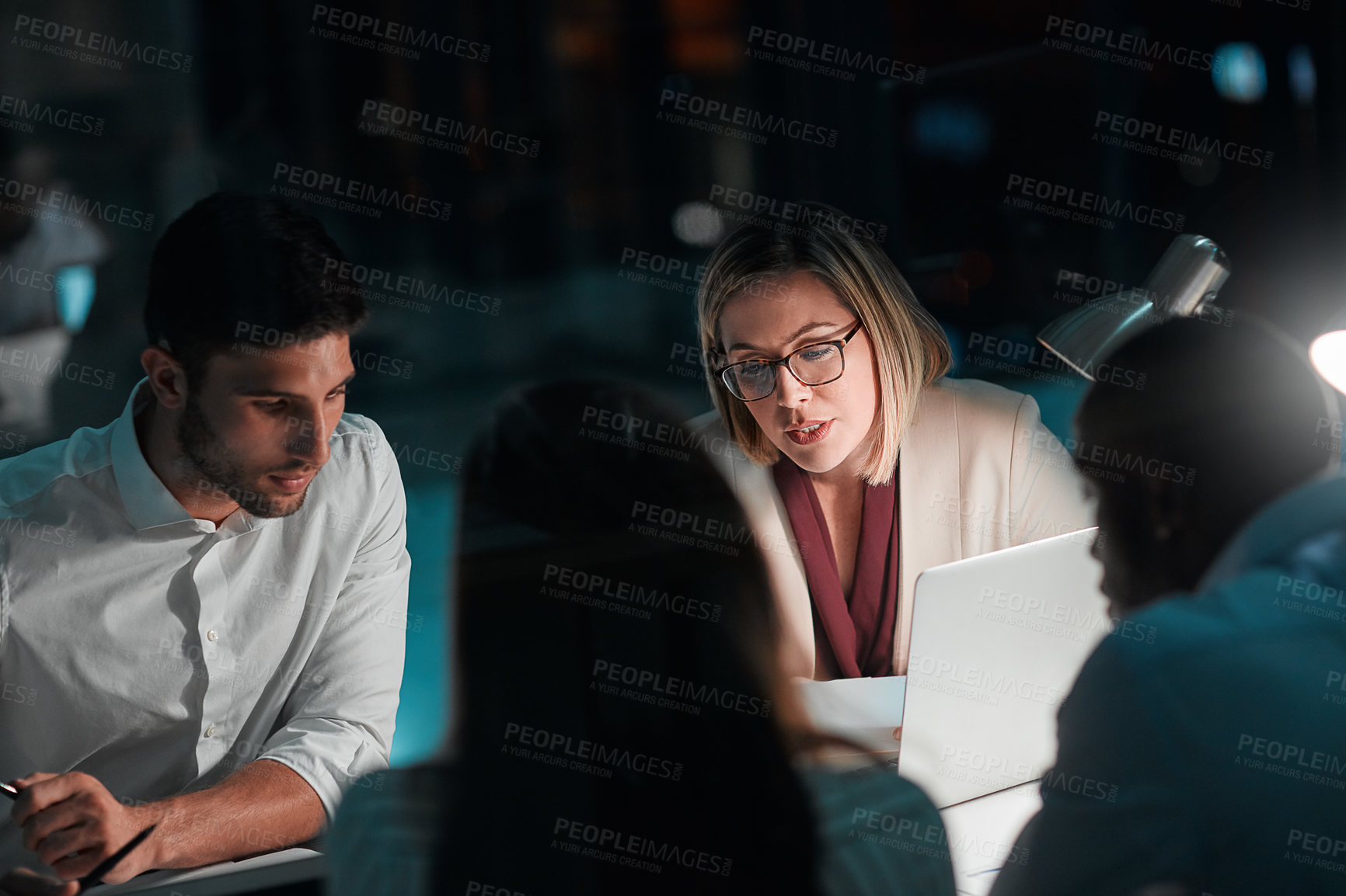 Buy stock photo Meeting, night and teamwork with laptop in office, reading and deadline for project and planning. Collaboration, online and business people, proposal and computer for financial records in boardroom