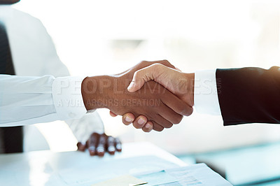 Buy stock photo Closeup shot of two unrecognizable businessmen shaking hands in the workplace