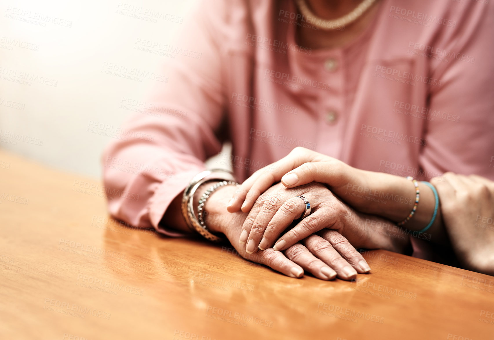 Buy stock photo Support, comfort and hands of people on table for empathy, compassion and trust in hope together. Home, love and women with gesture of understanding on desk for solidarity, forgiveness and kindness