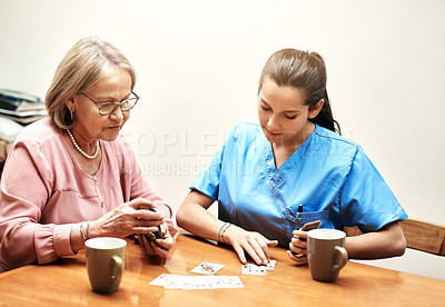 Buy stock photo Cropped shot of a senior woman playing cards with her caregiver