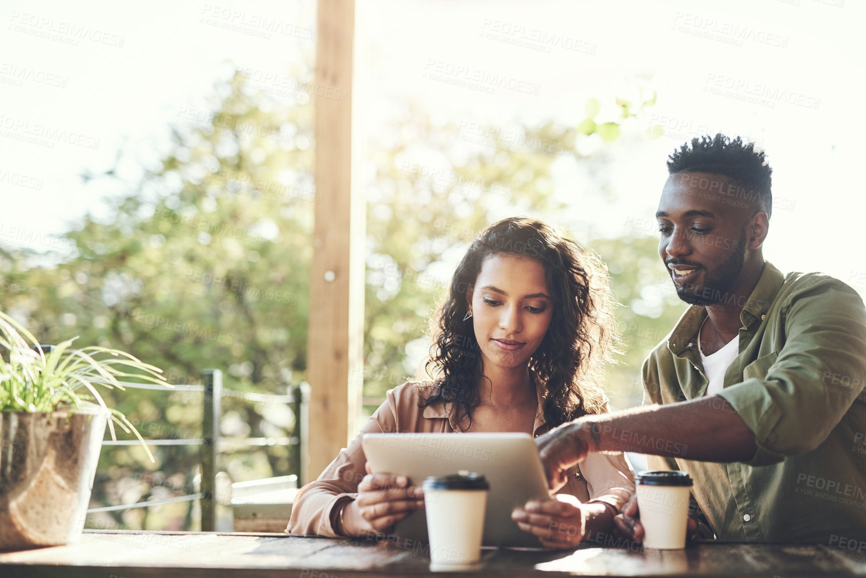 Buy stock photo Coffee, conversation and couple with tablet in restaurant for social media, update and relationship post. Happy, woman and man with technology in cafe for bonding, love and online communication