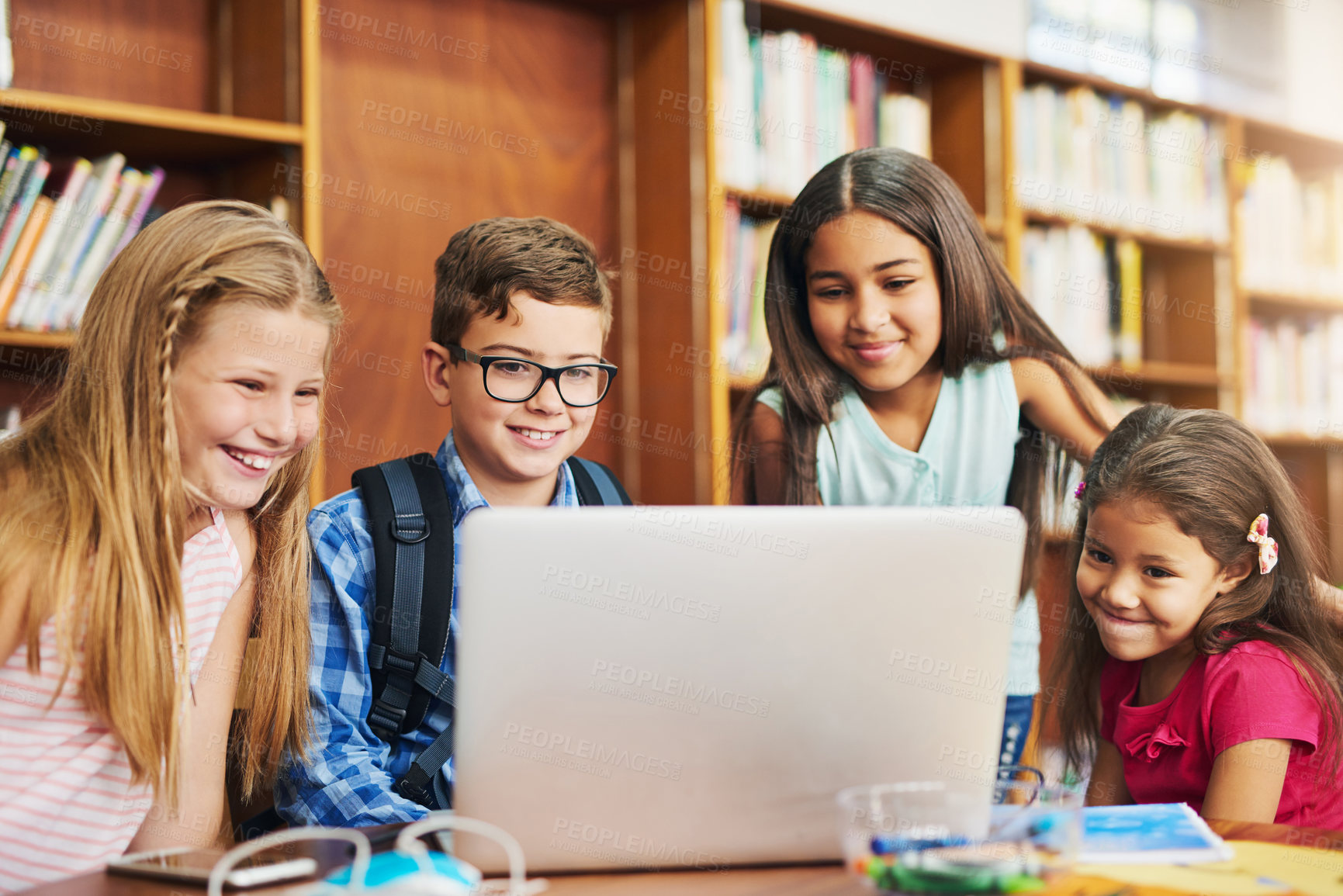 Buy stock photo Happy children, students or elearning with laptop at library for ebook, group project or virtual learning in school. Young, kids or kindergarten friends with smile on computer for online storytelling