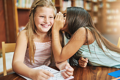 Buy stock photo Happy girl, whisper and ear with secret at library for gossip, funny rumor or joke in elementary school. Children, kids or young friends with smile for news, prank or playful learning at book store