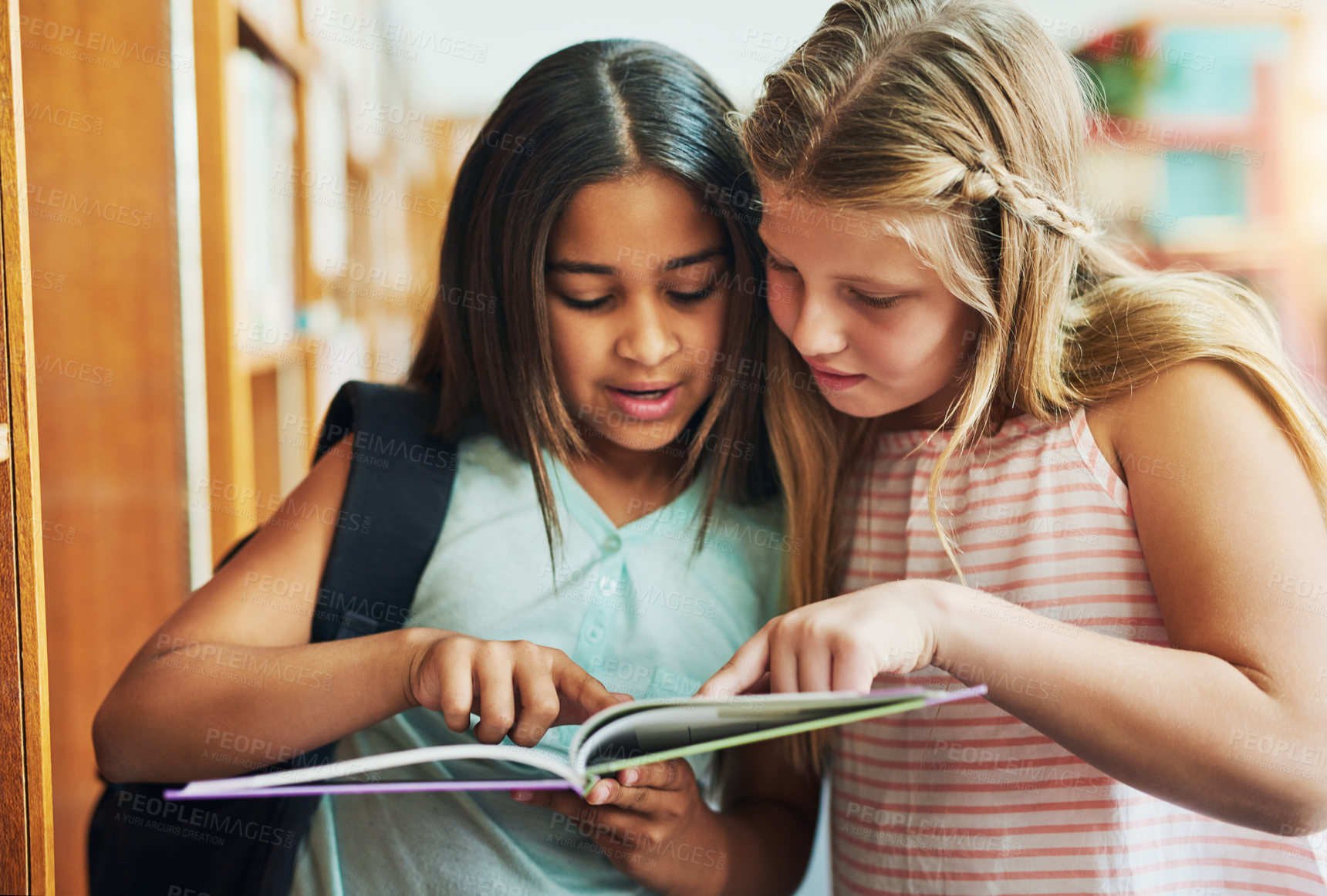 Buy stock photo School kids, girl and reading in library with book for educational story, fantasy fiction or literature. Friends, student and novel at academy for language development, study and curious for learning