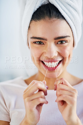 Buy stock photo Portrait of a beautiful young woman flossing her teeth in the bathroom at home