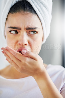 Buy stock photo Shot of a beautiful young woman checking her breath at home