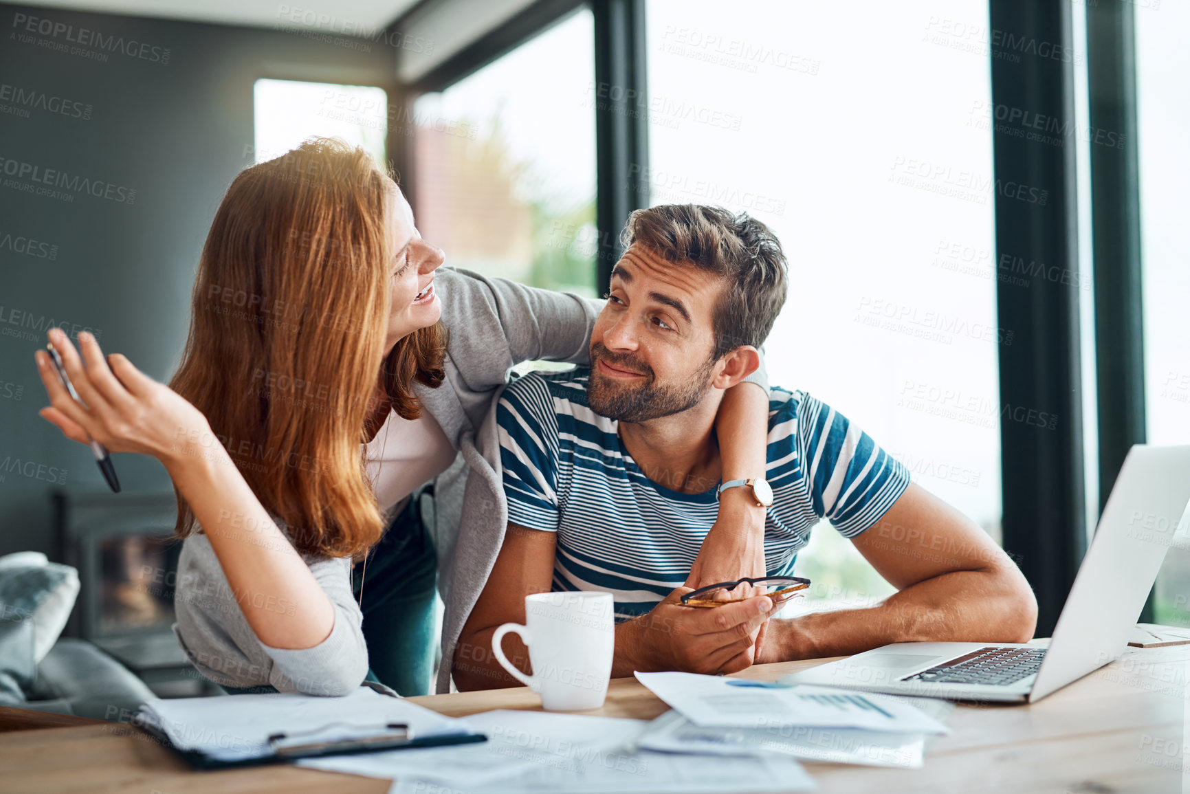 Buy stock photo Shot of an affectionate young couple working on their household budget