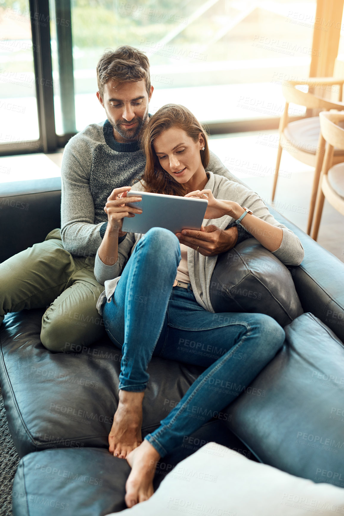 Buy stock photo Happy, couple and hug with tablet on couch for streaming, movie choice or tv selection on web app at home. Smile, man and woman with tech, subscription and bonding on sofa for connection and search