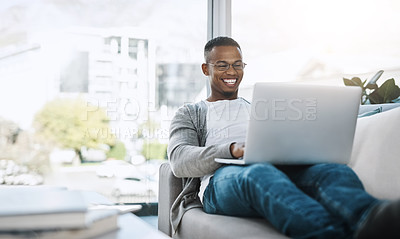 Buy stock photo Man, laptop and working on home sofa or remote work, elearning or distance job and online study, freelance or email communication. African male, happy on computer and apartment or living room 
