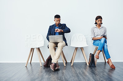 Buy stock photo Phone, laptop and people in waiting room for an internship search the internet, web or website sitting on chairs. Interview, work and young employees texting and typing online ready for a new job