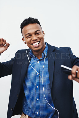 Buy stock photo Studio shot of a young creative businessman listening to music on his cellphone against a grey background