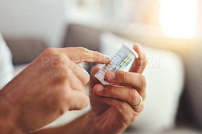 Buy stock photo Cropped shot of an unrecognizable young man about to take his medication at home